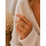 Main portant la bague Orane dorée à quatre anneaux avec pull mohair beige dans une ambiance douce et naturelle – bijou femme Bella Cosa