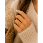 Main portant la bague Obella dorée avec pull mohair beige dans une ambiance douce et chaleureuse – bijou femme Bella Cosa
