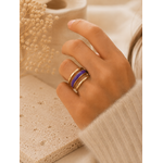 Main portant la bague Veha violette et dorée avec pull mohair beige dans une ambiance chaleureuse et élégante – bijou femme Bella Cosa
