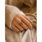 Main portant la bague Venda dorée avec pierres fuchsia dans une ambiance douce et élégante aux tons beige et caramel – bijou femme Bella Cosa
