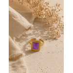 Bague Vélina dorée et violette posée sur travertin beige et tissu naturel dans une ambiance chaleureuse et raffinée – Bella Cosa