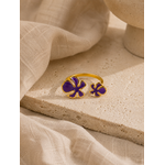 Bague Vélina dorée et violette posée sur travertin beige et tissu naturel dans une ambiance chaleureuse et raffinée – Bella Cosa
