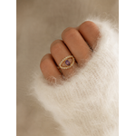 Main portant la bague Victoria dorée avec pierre violette sur pull mohair blanc tout doux dans une ambiance cosy et élégante – bijou femme Bella Cosa