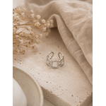Bague Pia argentée posée sur travertin beige et tissu naturel dans une ambiance douce et chaleureuse – Bella Cosa