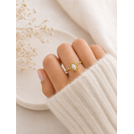 Main portant la bague Alba dorée avec pierre nacrée blanche sur pull mohair crème dans une ambiance cosy et naturelle – bijou femme Bella Cosa