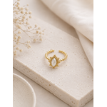 Bague Alba dorée avec pierre nacrée posée sur travertin beige et lin naturel dans une ambiance douce et chaleureuse – Bella Cosa