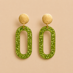 Boucles d’oreilles Clémentine citron vert en résine pailletée sur fond beige clair