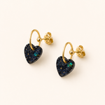 Boucles d’oreilles Cassie noires avec cœur en résine florale et anneau doré sur fond beige élégant