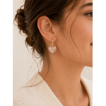 Boucles d’oreilles Cassie blanc glacier avec cœur translucide pailleté portées en lumière naturelle