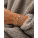 Accumulation de bracelets argentés fins et perlés portés sur poignet féminin – bijoux minimalistes et élégants Bella Cosa