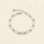 Bracelet Ginnie argenté à maille trombone minimaliste sur fond crème doux et épuré