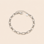 Bracelet Gaya argenté à mailles géométriques rectangulaires sur fond crème minimaliste et épuré