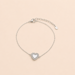 Bracelet Noa argenté avec cœur blanc nacré et zirconiums lumineux sur fond crème minimaliste