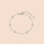 Bracelet Mona argenté avec petits zirconiums lumineux sur fond crème doux et minimaliste