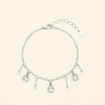 Bracelet Cerise argenté avec pampilles cristaux transparents sur fond beige doux minimaliste et lumineux style raffiné féminin