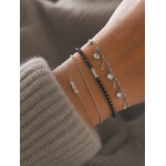 Bracelet Cerise argenté avec pampilles cristaux lumineux porté sur un poignet féminin avec maille douce beige et ambiance cosy raffinée