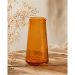 Pichet en verre bullé orange artisanal posé sur une table en bois dans une ambiance décoration naturelle et chaleureuse