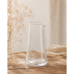 Pichet en verre bullé transparent artisanal posé sur une table en bois dans une ambiance décoration naturelle et chaleureuse