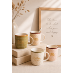 Mugs en porcelaine décoratifs avec détails dorés posés sur des livres en lin dans une décoration chaleureuse et minimaliste