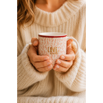 Femme tenant un mug Love More rose poudré dans une ambiance cosy et chaleureuse
