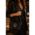 Femme portant le sac bandoulière noir Kacie en similicuir grainé avec fermoir bijou doré dans une ambiance chic et élégante de soirée