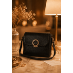 Sac bandoulière noir Kacie en similicuir grainé avec fermoir bijou doré dans une ambiance élégante et chaleureuse style soirée chic