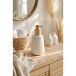 Distributeur à savon blanc texturé avec pompe en bois naturel posé sur un meuble de salle de bain minimaliste en bois clair dans une ambiance chaleureuse et élégante style slow living