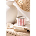 Bougie artisanale parfumée senteur cerise dans un pot style peinture rayé rose et blanc posée sur des livres dans une décoration chaleureuse et lumineuse slow living