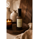 Parfum de maison senteur lait d’amande douce en verre ambré posé sur un plateau en bois foncé dans une décoration chaleureuse et naturelle slow living