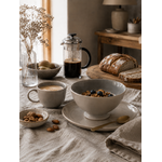 Bol en faïence gris taupe sur une table de petit-déjeuner chaleureuse