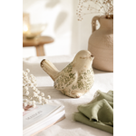 Figurine oiseau décorative en grès émaillé avec motif feuillage vert, posée sur une table en lin dans une décoration naturelle et chaleureuse.