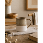 Mug en grès Arya beige et blanc en finition émaillée et mate, posé sur une table en bois dans une ambiance chaleureuse et naturelle pour le café ou le thé.