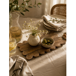 Plateau de service en bois de manguier sculpté à la main présenté sur une table chaleureuse avec carafe en verre, vaisselle en céramique et linge en lin naturel.