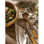 Couverts à salade en bois de manguier assortis au saladier de la collection naturelle Bella Cosa, présentés dans une ambiance chaleureuse sur une table de cuisine.