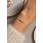 Bracelet Flora argenté en acier inoxydable porté au poignet, bijou fin avec feuille délicate dans une ambiance douce et élégante.