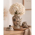 Vase Tibor en grès écru à motifs floraux noirs utilisé avec un hortensia blanc, accompagné de la boule décorative assortie.