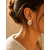 Boucles d’oreilles Caroline dorées en forme de cœur pailleté portées lumière naturelle chaleureuse
