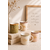 Mugs en porcelaine décoratifs avec détails dorés posés sur des livres en lin dans une décoration chaleureuse et minimaliste