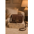 Sac bandoulière marron Amy en similicuir lisse posé sur des livres dans un intérieur cosy aux tons crème et caramel