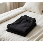 Pantalon noir série n°2 plié sur le lit