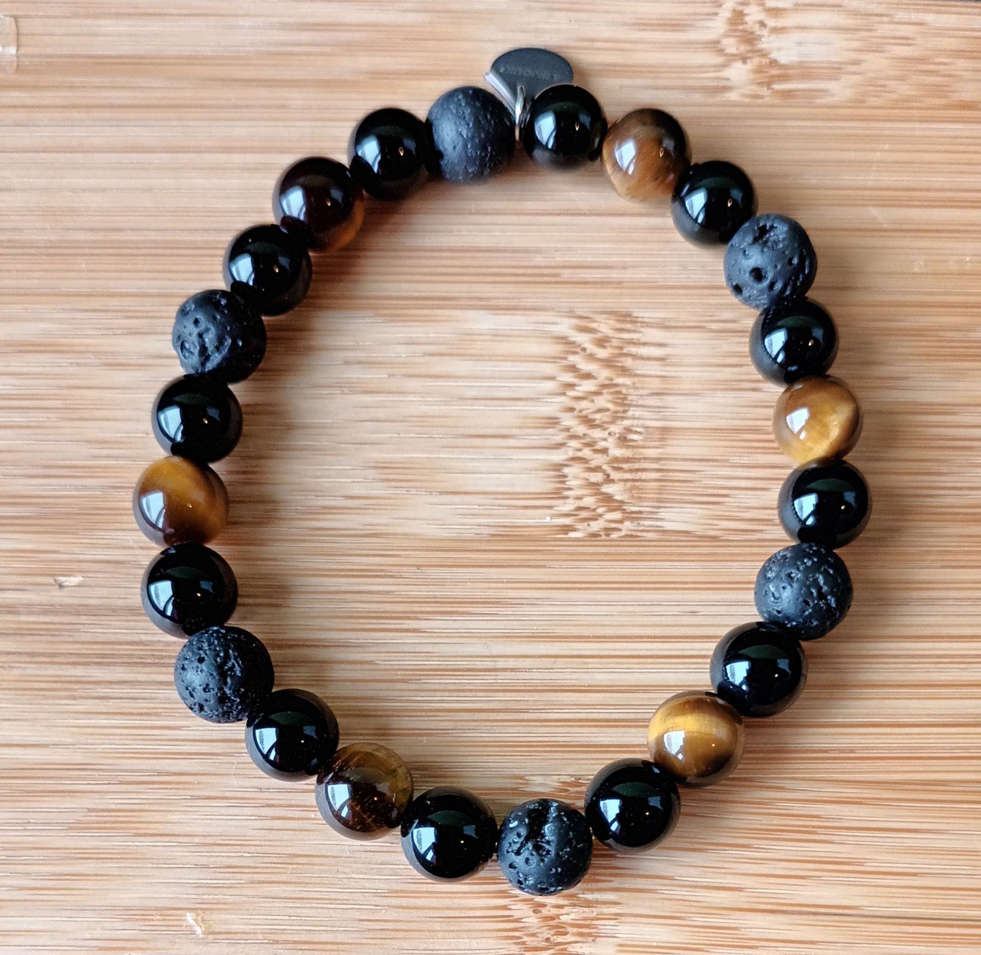 Bracelet en perles d'œil de tigre, de lave et d'agate noire. Graines de Love.
