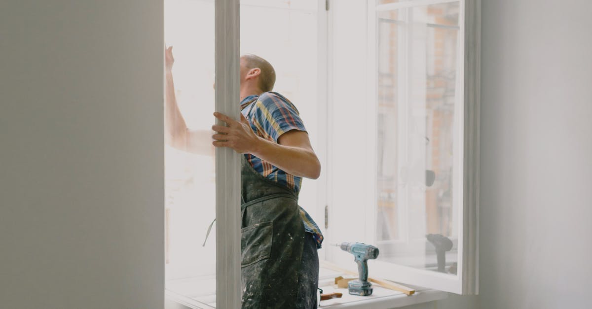 un ouvrier meconnaissable installe une fenetre dans un nouvel appartement