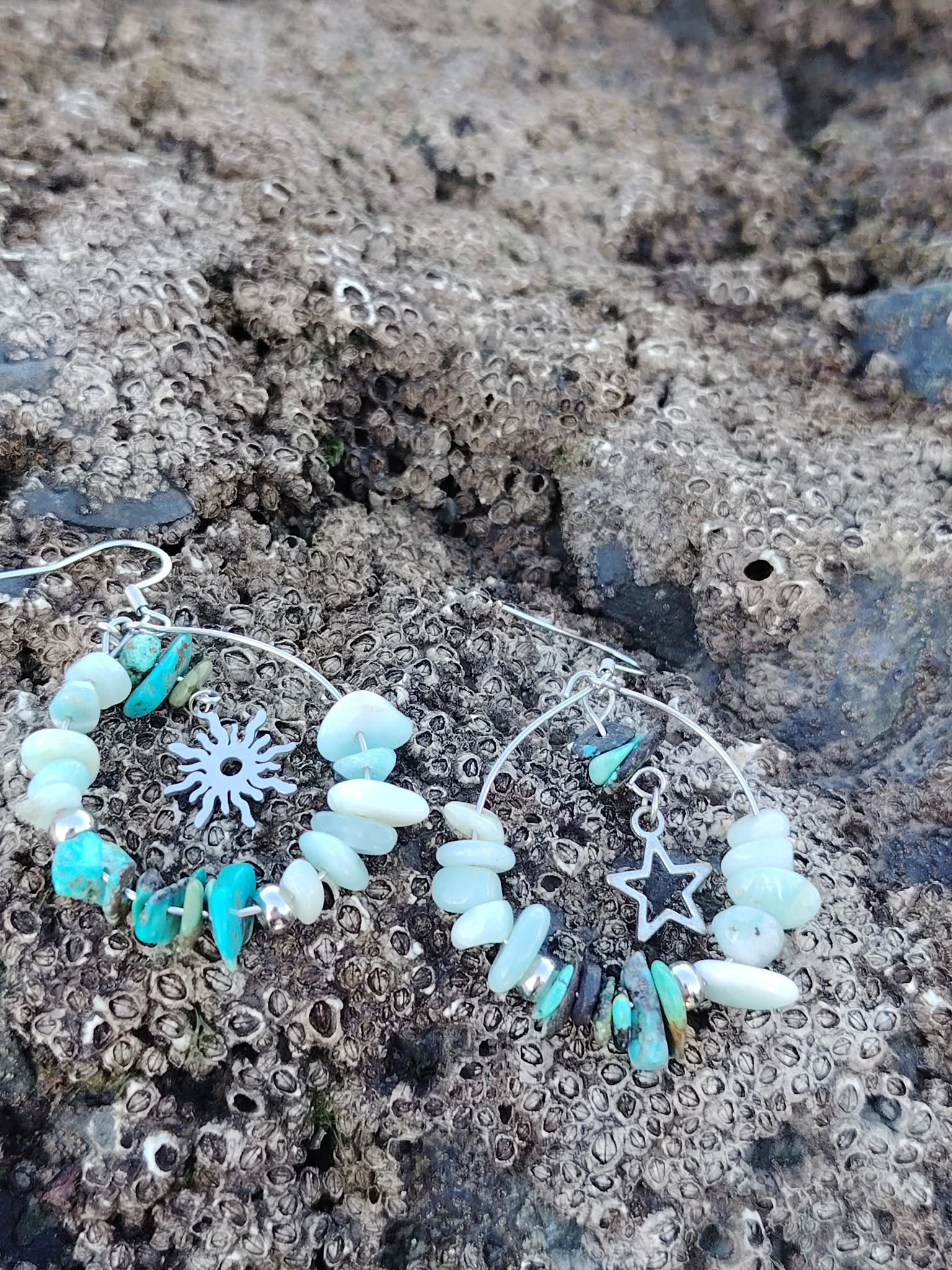 Boucles d’oreilles Ombre et Lumière, création Magic Gaïa, perles turquoise et blanches avec breloques, posées sur rocher breton, pour calme intérieur, confiance et protection douce.