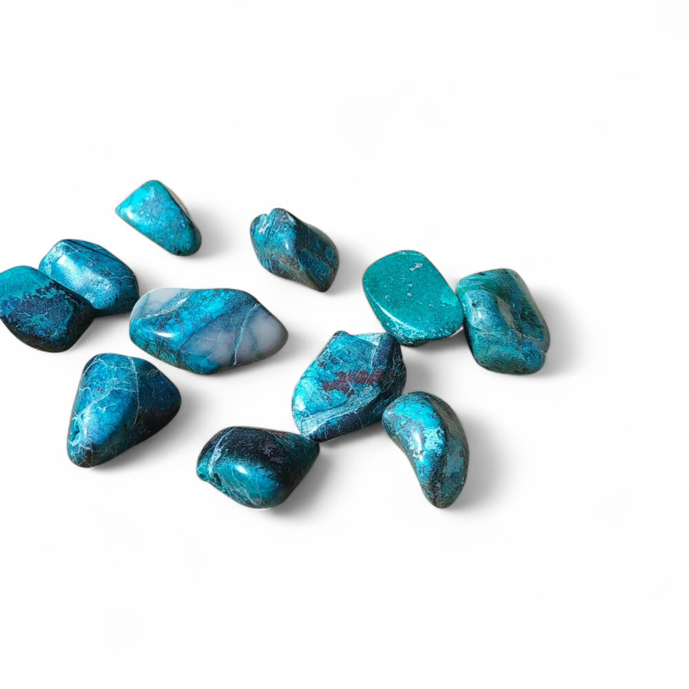 Galets de chrysocolle bleu-vert sur fond blanc épuré, pierres roulées aux nuances marbrées reliées à la clarté d’esprit, à l’expression posée et à la sérénité.