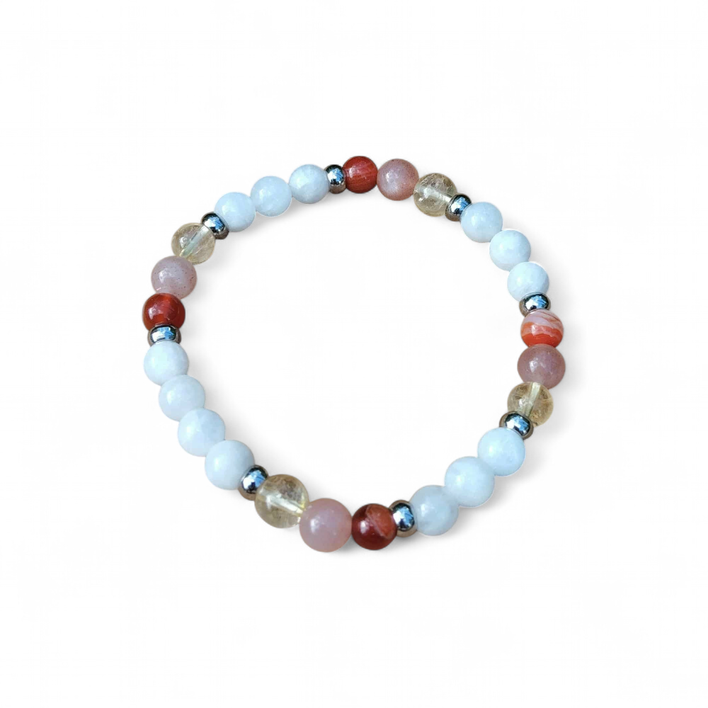 Bracelet PMA 6 mm en péristérite, pierre de soleil et cornaline, posé sur champignons en bois et feuillage vert; douceur, optimisme et élan intérieur.