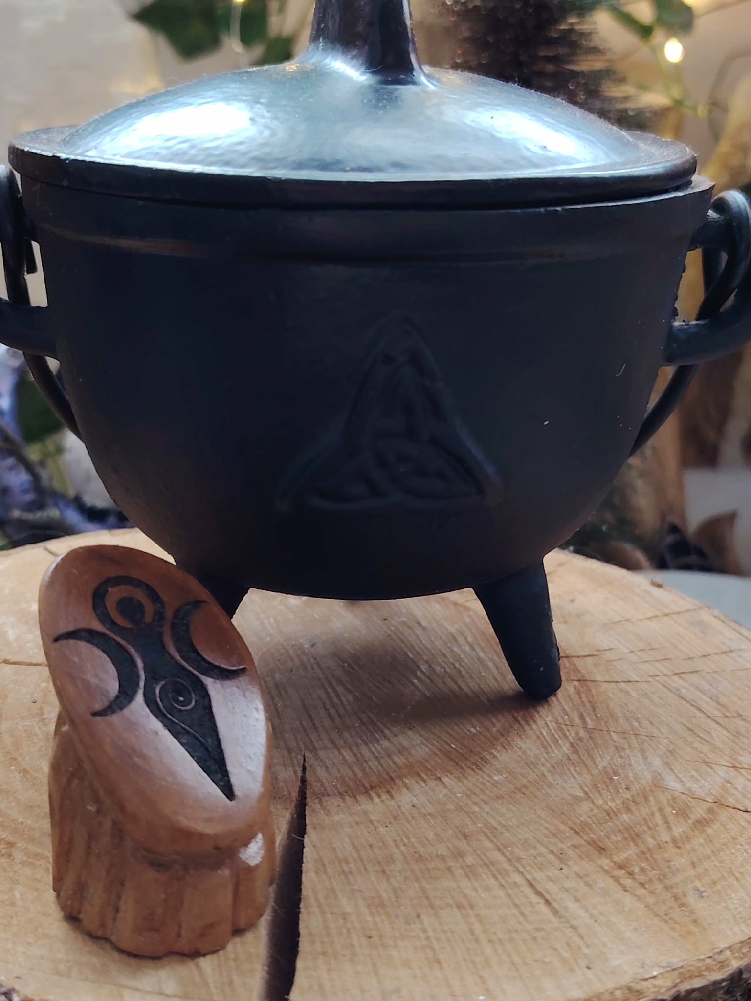 Chaudron en fonte noire avec symbole Triquetra gravé sur planche en bois, accessoire ésotérique pour encens, résines et rituels.