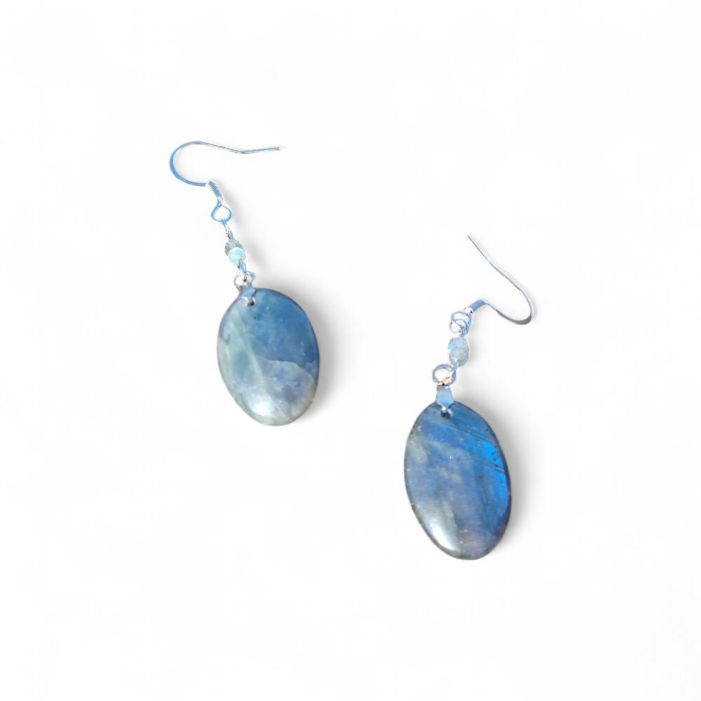 Boucles d’oreilles Labradorite création Magic Gaïa sur fond blanc lumineux, crochets argentés, reflets bleutés; intention: protection douce et clarté.