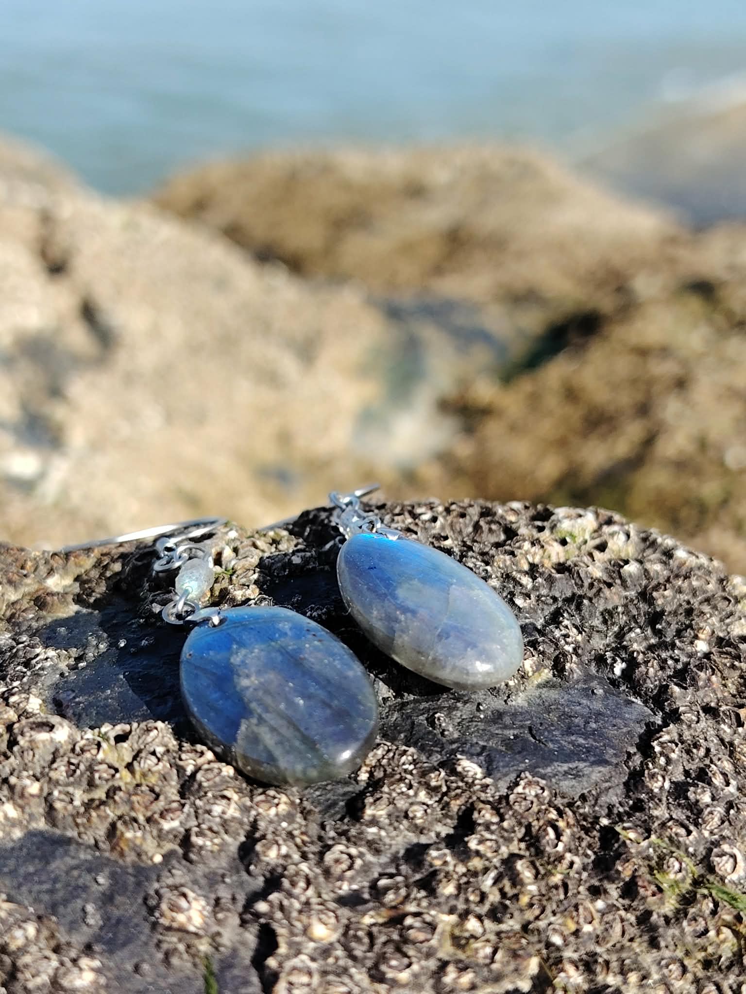 Boucles d’oreilles Labradorite création Magic Gaïa sur mousse en forêt près d’une cascade; intention: recentrage, protection, respiration intérieure.