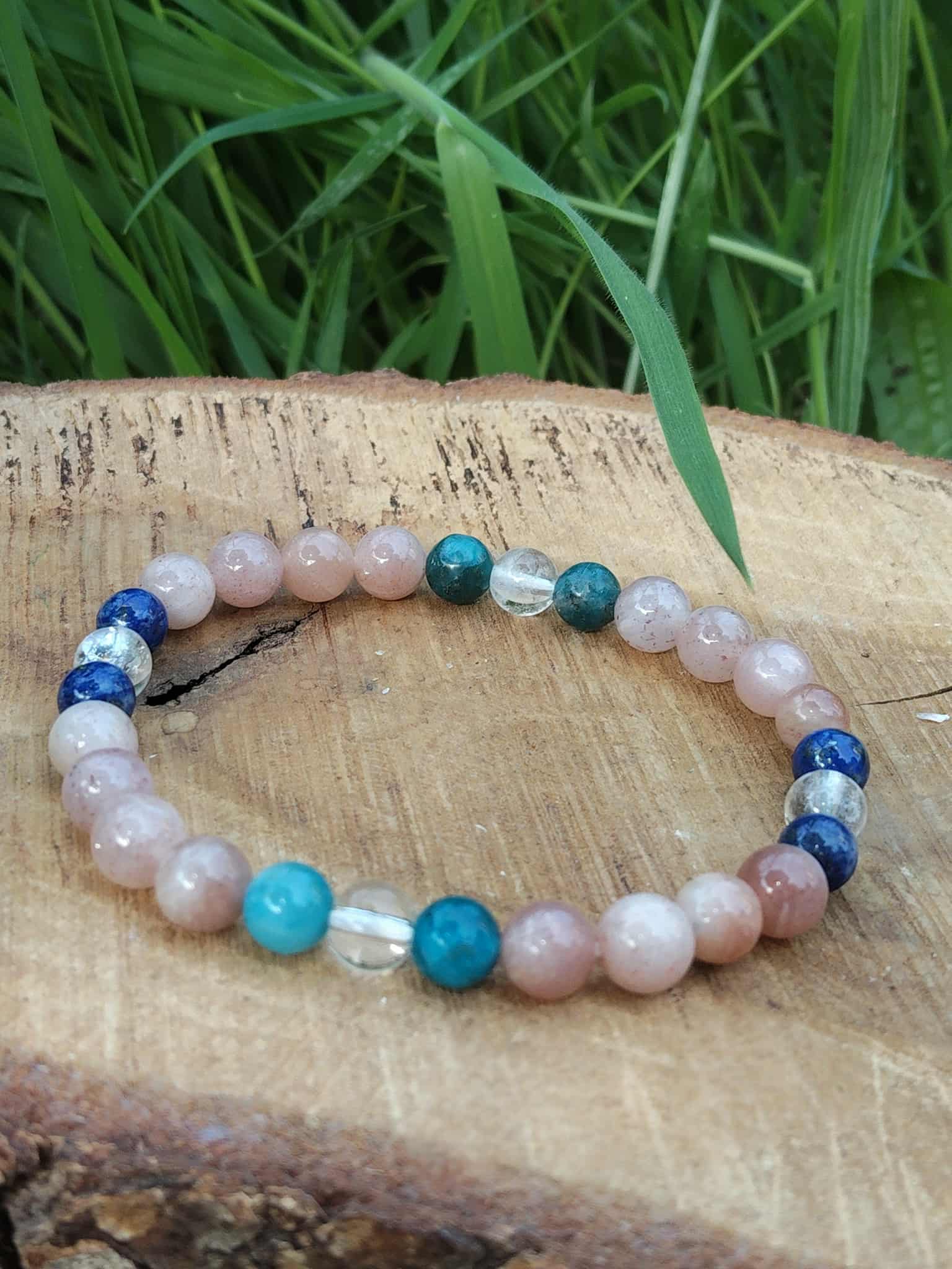 Bracelet bien-être 6 mm création Magic Gaïa sur bois brut avec herbe floutée, pierre de soleil pêche, lapis-lazuli, apatite et cristal de roche pour élan positif et expression sereine