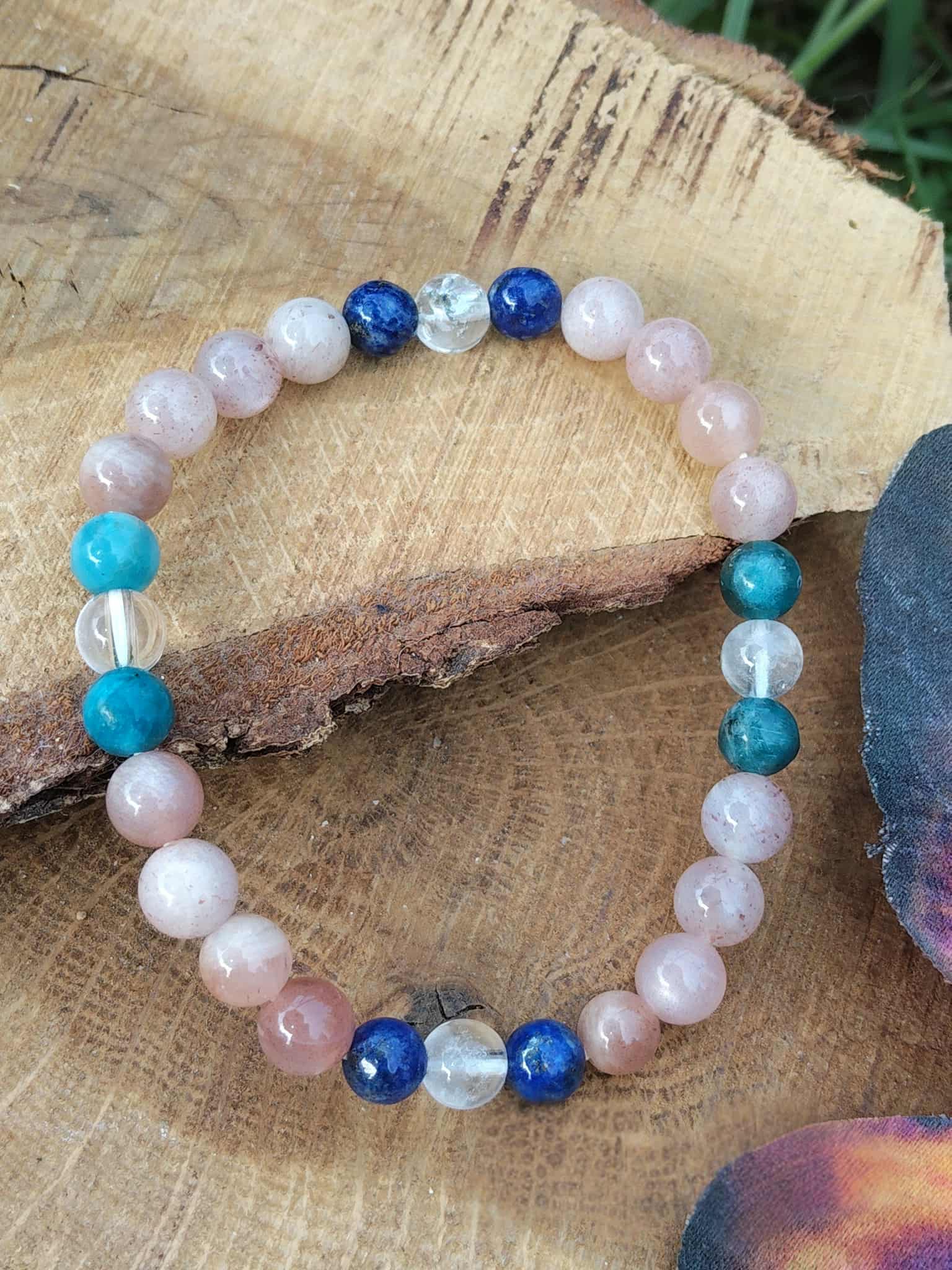Bracelet bien-être création Magic Gaïa sur tranche de bois brut avec plume irisée, perles 6 mm pour joie du cœur, inspiration et aisance relationnelle